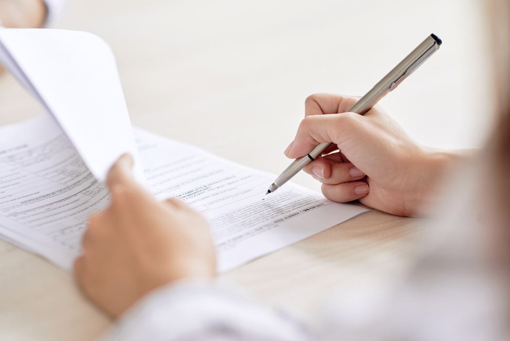 Person signing an employment agreement at a desk