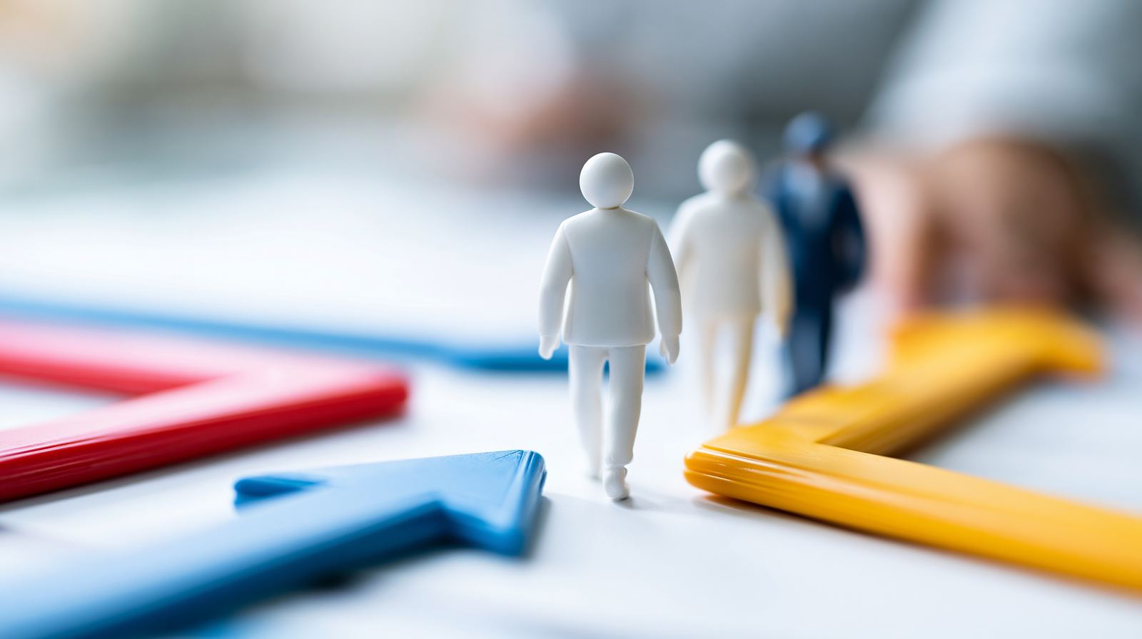 Small figures standing where coloured arrows point in different directions